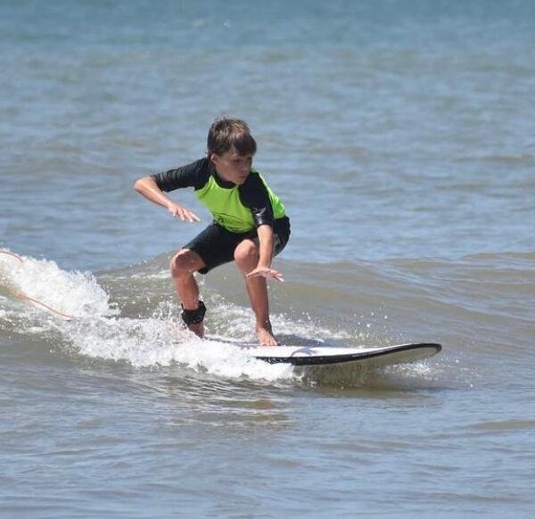 Un niño aprediendo a surfear