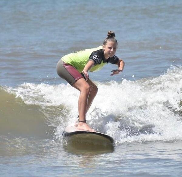 Una niña aprediendo a surfear