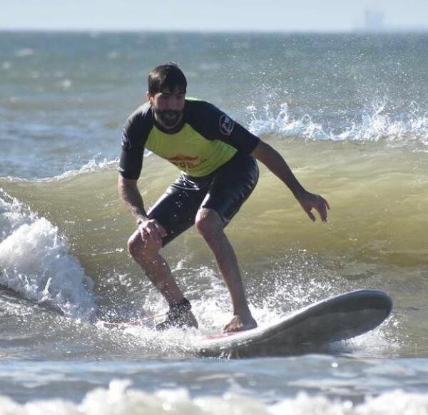 Un hombre aprediendo a surfear