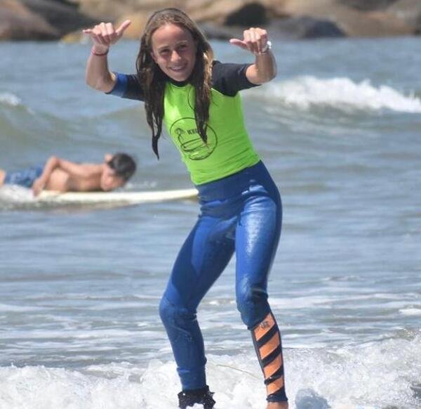 Una niña aprediendo a surfear
